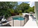 Backyard pool featuring lush landscaping, a waterfall feature, and privacy fencing at 643 Blenheim Loop, Winter Springs, FL 32708