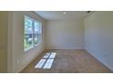 Well-lit carpeted bedroom with a large window providing natural light and outdoor views at 2005 Carnostie Rd, Winter Haven, FL 33884