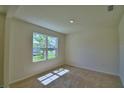 Bright, carpeted bedroom featuring a large window, offering natural light and outdoor views at 2005 Carnostie Rd, Winter Haven, FL 33884