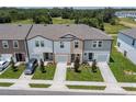 An aerial view of the townhouses showing green lawns and paved driveways at 3431 Vesara Dr, Davenport, FL 33837