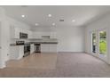 Spacious living area with kitchen featuring white cabinets and stainless steel appliances at 3431 Vesara Dr, Davenport, FL 33837