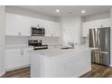 Modern kitchen featuring white cabinets, stainless steel appliances, and a center island at 3730 King Hill Dr, Haines City, FL 33844