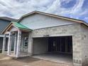 Home under construction features a covered front porch and garage with concrete walls and a partially completed roof at 5728 Haystack Drive, St Cloud, FL 34771