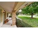 Welcoming front porch featuring brick columns, manicured landscaping, and a scenic neighborhood view at 6642 Parson Brown Dr, Orlando, FL 32819