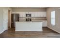 Bright kitchen featuring stainless steel appliances, a large island, and sleek white cabinetry at 1229 Tidal St, Haines City, FL 33844