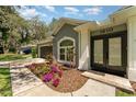 Close-up of home's entrance, featuring a colorful flowerbed, a well-manicured lawn and a paved walkway at 1610 Sherwood Lakes Blvd, Lakeland, FL 33809