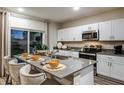 Bright kitchen featuring modern appliances, white cabinets, a gray island with barstools, and decor at 4003 Gardenia Ave, Lake Hamilton, FL 33851