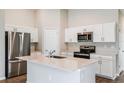 Modern kitchen with stainless steel appliances, white cabinets, and a center island at 4011 Gardenia Ave, Lake Hamilton, FL 33851