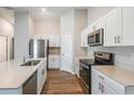 Bright kitchen featuring stainless steel appliances, white cabinetry, and quartz countertops at 4011 Gardenia Ave, Lake Hamilton, FL 33851