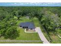 Expansive aerial view of property featuring a spacious lot, wooden fencing, and mature trees at 5080 Maple Dr, Lakeland, FL 33810