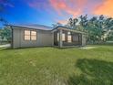 Backyard view showcasing the screened porch, expansive lawn, and privacy at 5080 Maple Dr, Lakeland, FL 33810