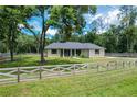 Charming single-story home with a spacious front yard surrounded by wooden fencing at 5080 Maple Dr, Lakeland, FL 33810