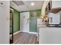 Small kitchen with modern appliances, tile backsplash, light cabinets, and a 