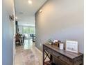 Inviting hallway with neutral paint and tile flooring leading to a well-lit open concept living space at 67 Bella Oaks Dr, Port Orange, FL 32129