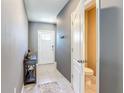 Entrance with gray walls, tile flooring, and coat hooks leading to the half-bath at 67 Bella Oaks Dr, Port Orange, FL 32129