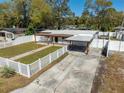 Charming home featuring a spacious driveway, manicured lawn, and white picket fence at 1616 Huntington St, Lakeland, FL 33801