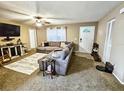 Cozy living room with a large sectional sofa and neutral carpet, bathed in natural light from the front door at 1841 Talmadge St, Deland, FL 32724