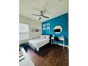 Stylish bedroom with a bright blue accent wall and modern decor with wood floor at 2864 Running Brook Cir, Kissimmee, FL 34744