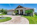 Charming single-Gathering home featuring a brick paved driveway, two car garage, and tropical landscaping at 3249 Pearly Dr, Lakeland, FL 33812
