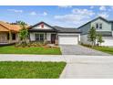 Inviting home exterior featuring a landscaped front yard, red door, gray driveway pavers, and a two-car garage at 6068 Sacred Oak Ave, Mount Dora, FL 32757