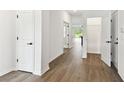 Bright hallway with modern flooring, white walls, black hardware, and doorways leading to other rooms at 6068 Sacred Oak Ave, Mount Dora, FL 32757