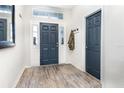Welcoming foyer featuring wood-look flooring, a stylish front door, and a convenient coat rack at 887 Galloway St, Lake Alfred, FL 33850