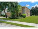 Attractive home featuring lush landscaping, a two-car garage, and a screened-in porch at 886 Suffolk Pl, Davenport, FL 33896