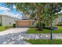 Charming home featuring a well-manicured lawn, a two-car garage, and mature trees providing shade at 886 Suffolk Pl, Davenport, FL 33896
