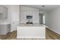 Modern kitchen features white cabinets, stainless steel appliances, gray countertops and an island with a sink at 9619 Sw 62Nd Ct, Ocala, FL 34476