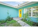 Bright yellow front door with a charming entry and well-kept landscaping at 1910 Sylvester Ct, Lakeland, FL 33803