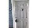 Close-up of a white front door with a door knocker and electronic lockbox at 709 Secret Harbor Ln # 313, Lake Mary, FL 32746