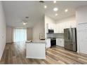 Modern open-concept kitchen featuring granite countertops, stainless steel appliances, and ample cabinet space at 1737 N Lakewood Ave, Ocoee, FL 34761