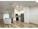 Bright and open kitchen with white cabinets, stainless steel appliances, and island with sink at 1737 N Lakewood Ave, Ocoee, FL 34761