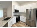 Close-up of kitchen showcasing granite countertops, stainless steel appliances, and white cabinetry at 1737 N Lakewood Ave, Ocoee, FL 34761