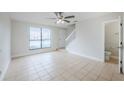 Bright living room features tile flooring and a staircase, offering ample space with convenient access to a powder room at 609 Casa Park N Ct, Winter Springs, FL 32708