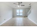 Bright living room with large window, tile flooring, and a staircase leading to the upper level in this townhome at 609 Casa Park N Ct, Winter Springs, FL 32708