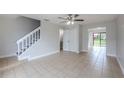 Spacious living area features tiled flooring and staircase that leads to the upper floor, enhancing the townhome's charm at 609 Casa Park N Ct, Winter Springs, FL 32708