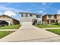 Well-maintained two-story home featuring a green lawn, blue shutters, and a two-car garage on a sunny day at 623 Grove St, Winter Haven, FL 33881