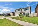 Two-story home boasts well-maintained lawn, driveway, with blue shutters on a bright sunny day at 623 Grove St, Winter Haven, FL 33881