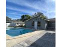 Backyard swimming pool with a concrete deck and adjacent building under a sunny sky at 1420 Wood Ave, Haines City, FL 33844
