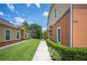 Manicured lawn leads up to a two-story home with green bushes and orange accent around the exterior at 4034 Winding Vine Dr, Lakeland, FL 33812