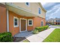 Front exterior entrance with a brown front door, a manicured lawn and minimal garden at 4034 Winding Vine Dr, Lakeland, FL 33812