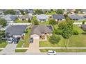 An aerial view of a residential home with solar panels, a brick driveway, and a well-kept lawn in a suburban neighborhood at 311 Bentley Oaks Blvd, Auburndale, FL 33823