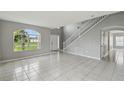 Spacious living room boasts tile floors, light gray walls, large windows, and a staircase at 811 Abbeville Ct, Kissimmee, FL 34759