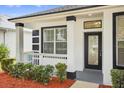 Inviting covered porch with white railings, decorative columns, and a glass-paneled front door at 1760 Mountclair Ct, Mount Dora, FL 32757