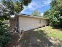 Side view of house shows exterior wall, green yard and surrounding trees at 2656 Williston Dr, Lakeland, FL 33801