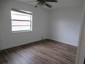 Comfortable bedroom with light-colored walls, wood-look floors and a bright window at 661 Lake Carolyn Cir, Lakeland, FL 33813