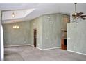 Open-concept living room with high ceilings, neutral carpet, and decorative chandelier at 3629 Welsh Way, Lakeland, FL 33813
