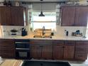 Cozy kitchen features a stainless steel sink, wood cabinets, and bright light from the window at 4119 Chambers St, Lake Wales, FL 33898