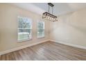 Bright dining area featuring wood-look floors, a modern chandelier, and large windows for natural light at 4189 Homestead Dr, Lakeland, FL 33810